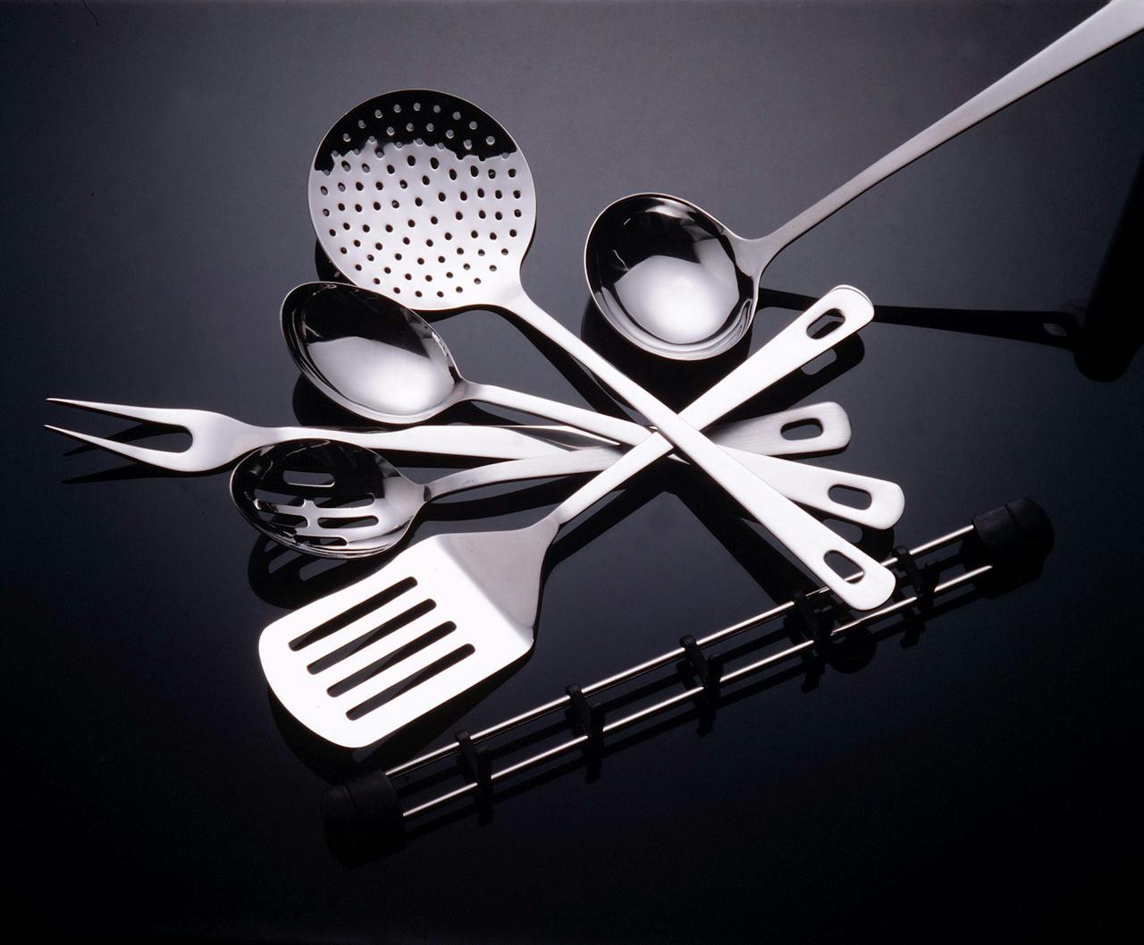 Collection of stainless steel kitchen utensils on a sleek black surface.